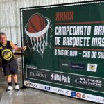 Jogador de basquete Tony Ventura posa ao lado de mural do Campeonato Brasileiro de Basquetebol Master